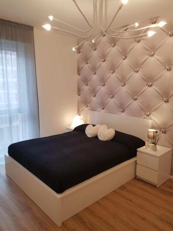 帕多瓦BSUITES TRIESTE的一间卧室配有一张大床和软垫床头板