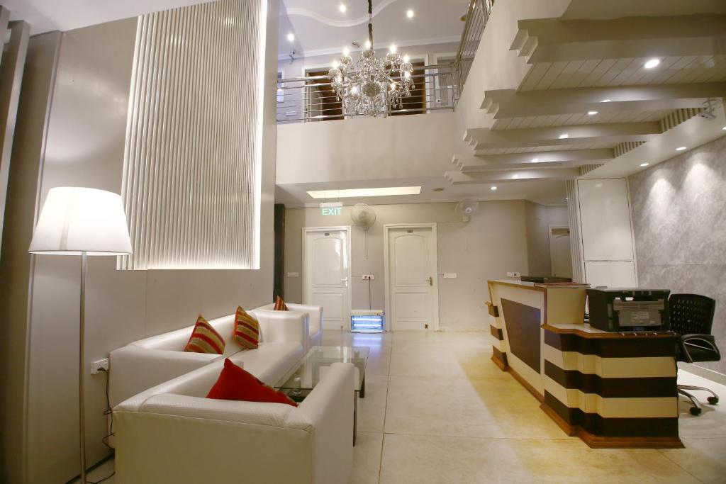 钱德加尔戴蒙德普拉扎酒店的客厅配有白色家具和吊灯。