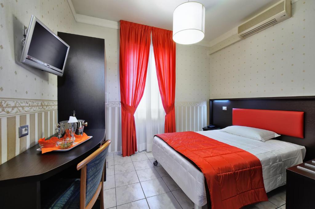 莱尼亚诺拉库尔苏酒店的一间卧室配有一张床、一张书桌和一台电视