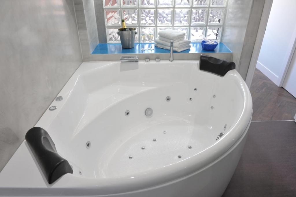 巴塞罗那巴塞罗那加乌丁特套房酒店的带窗户的浴室内的白色浴缸