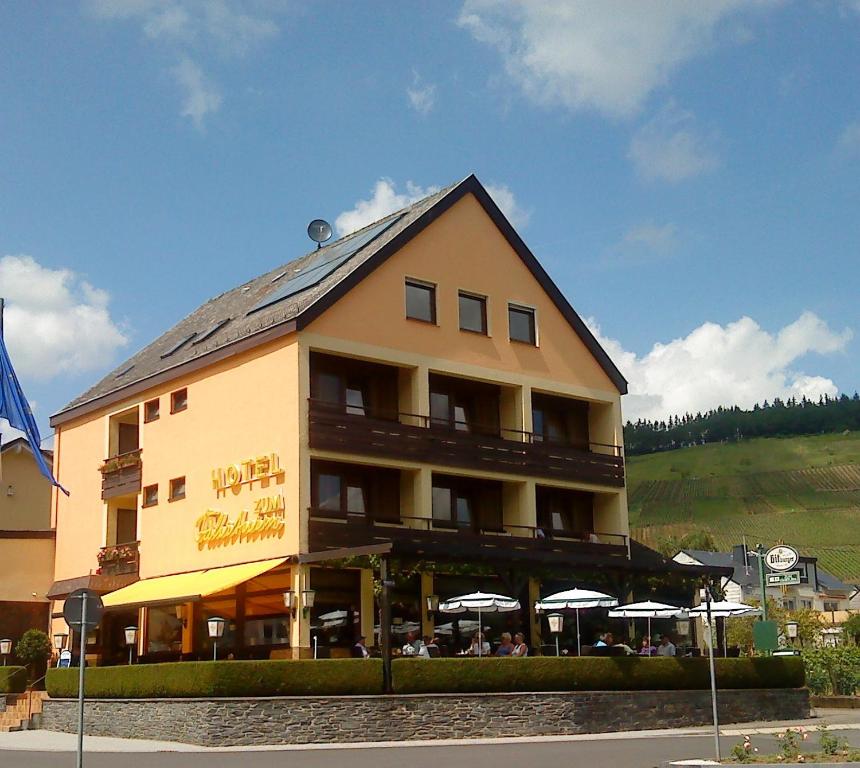 梅灵Hotel Zum Fährturm的前面有雨伞的大建筑