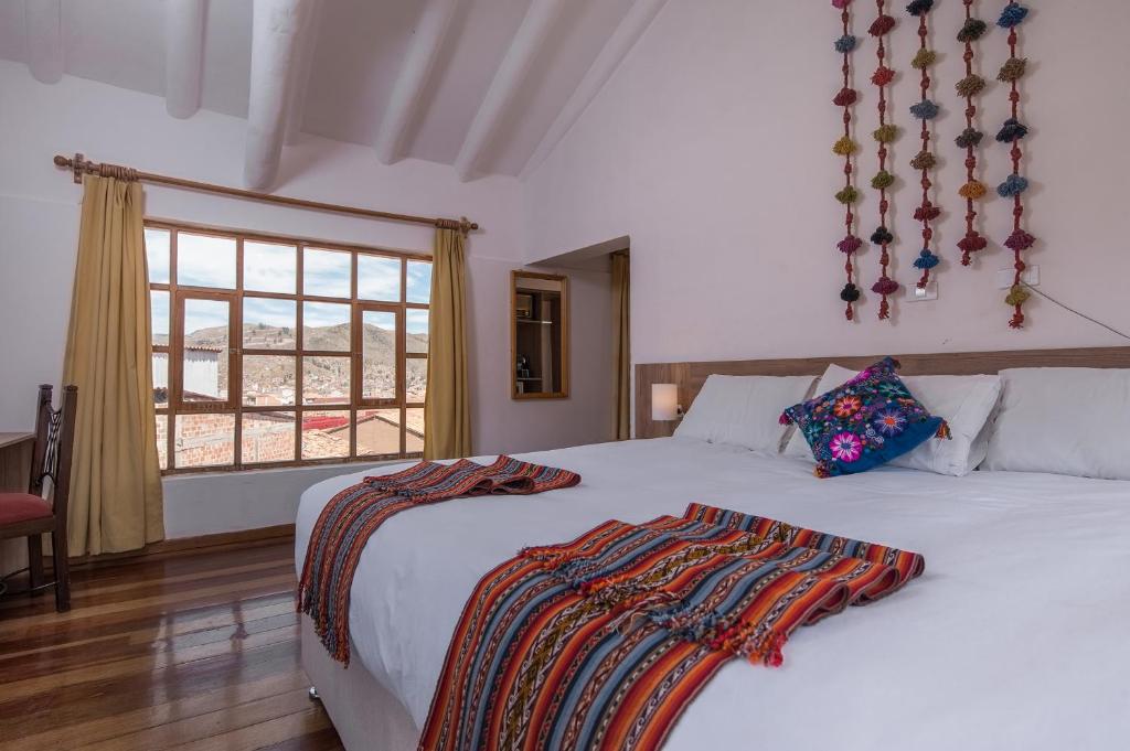 库斯科Inkarri Cusco的一间卧室设有两张床和窗户。