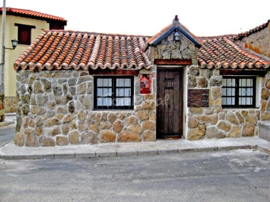 PadiernosCasa rural El Rincón的街道上一扇带门窗的石头建筑