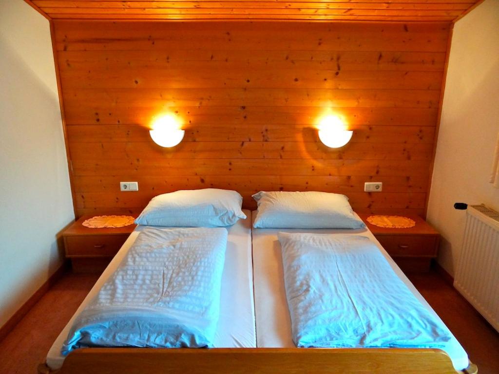萨尔巴赫玛丽亚滑雪和自行车膳食公寓的一间卧室配有两张床,墙上有两盏灯
