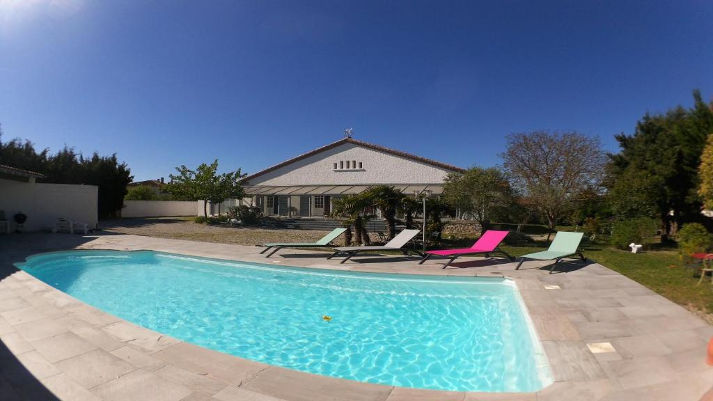 Caux-et-SauzensAux Belles Vacances的一个带椅子的游泳池以及一座房子