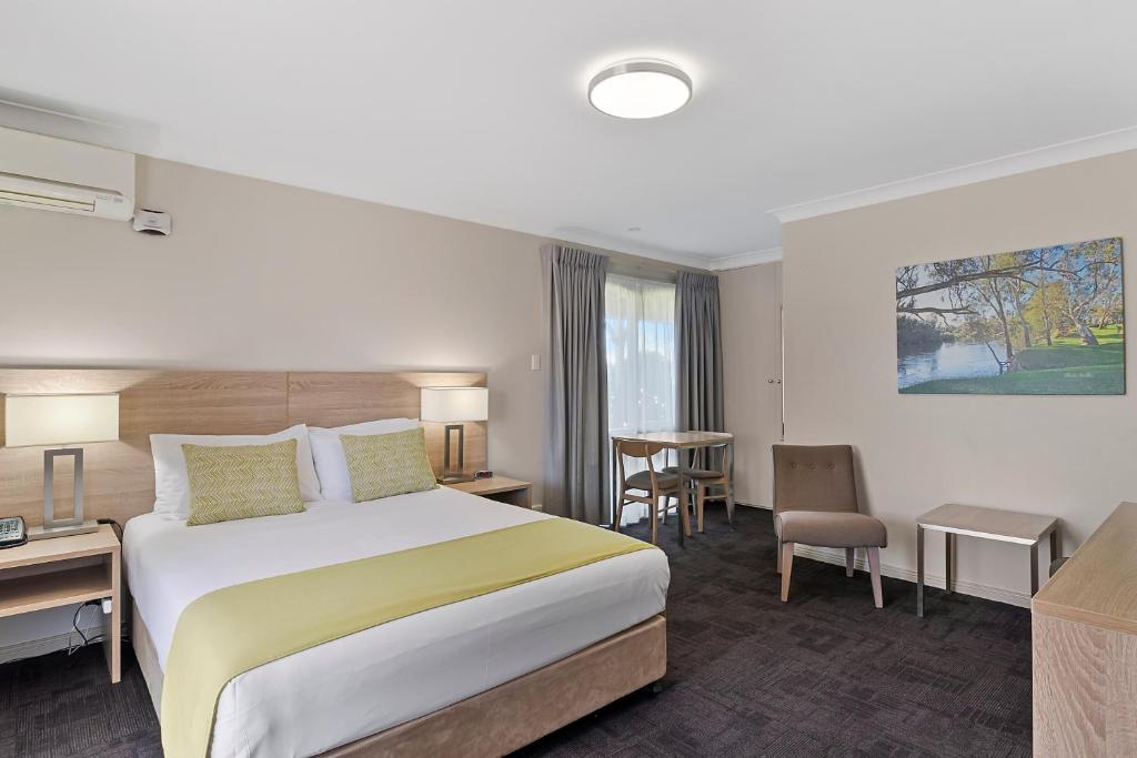 沃加沃加卡里奇豪斯品质酒店的配有一张床和一张书桌的酒店客房