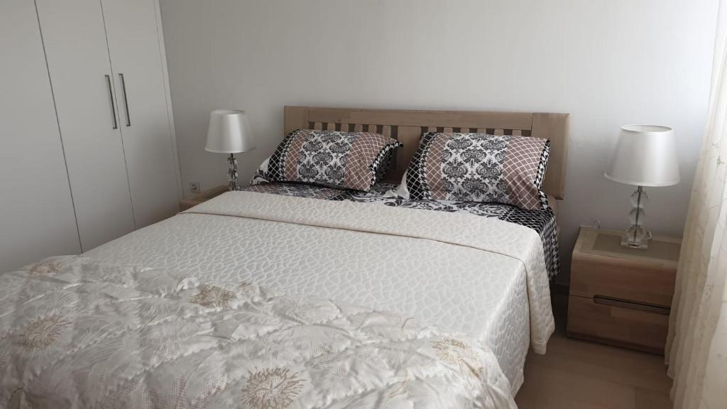 斯普利特Fortuna Rajna Apartman的一间卧室配有一张带枕头的床和两盏灯。