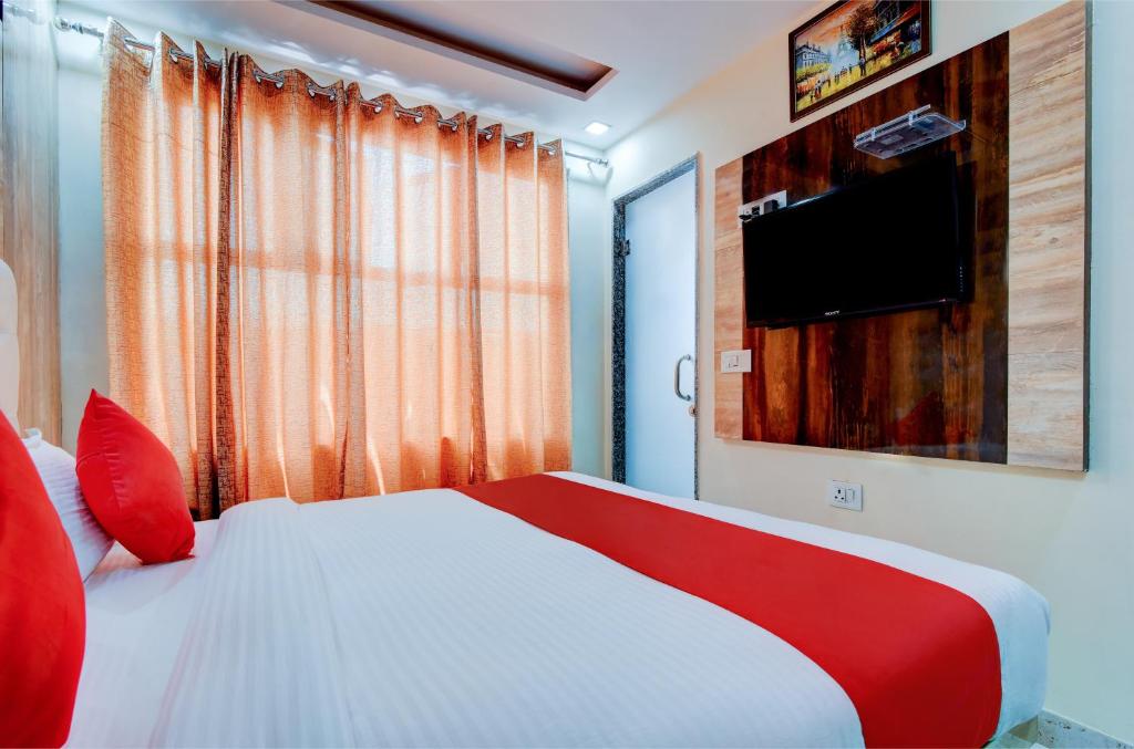 新德里Delhi Guest House的卧室配有一张床铺,墙上配有电视
