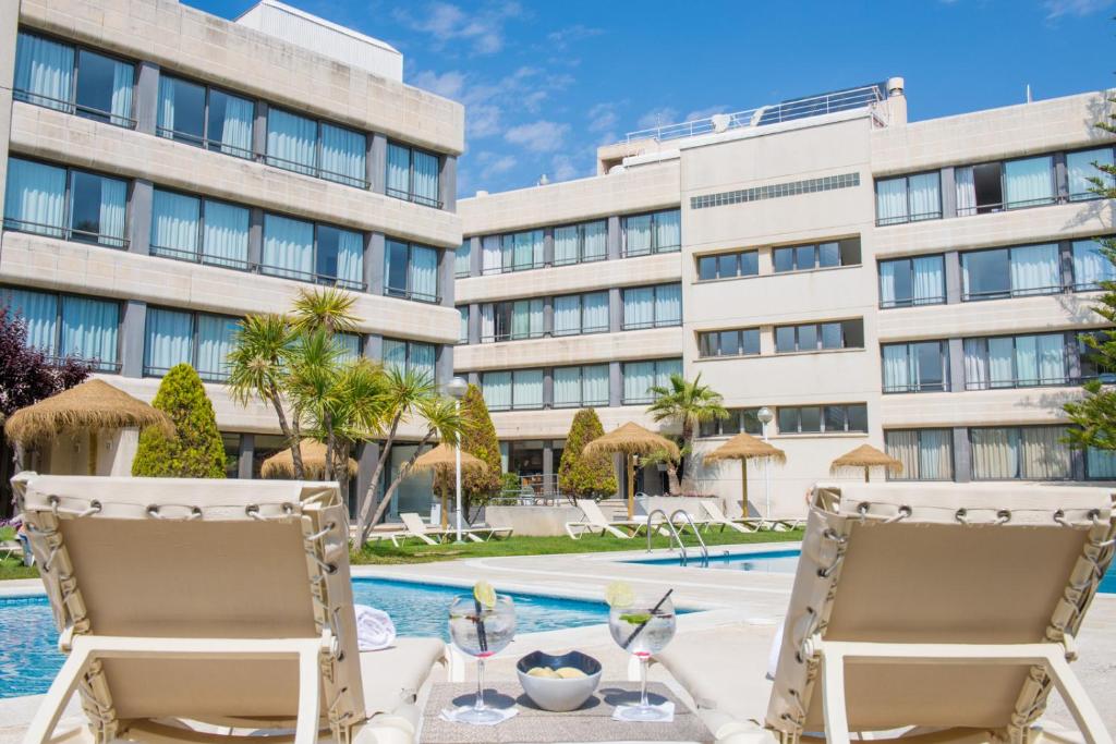 比利亚努埃瓦-赫尔特鲁雅典娜公园套房公寓的享有度假村的景致,配有2把椅子和游泳池。