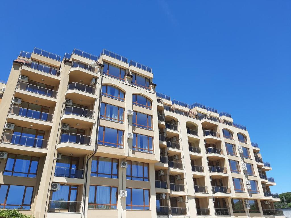 金沙Vesta Riviera - Free Parking的公寓大楼的背景是蓝色的天空