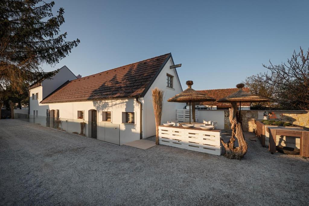 Schützen am GebirgePresshaus Schützen的白色的建筑,配有桌子和雨伞