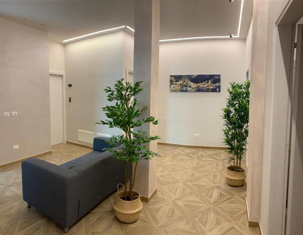 帕加尼Domus Monasteire的客厅配有蓝色沙发和两株盆栽植物
