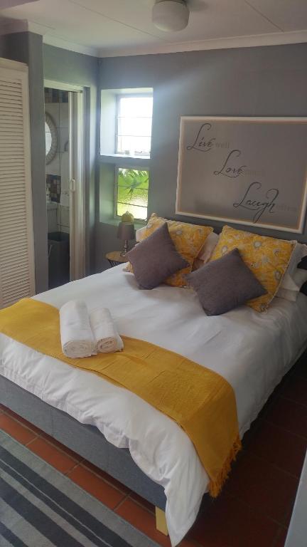 比勒陀利亚Love Joy Peace Cottage的一张大床,上面有两条毛巾