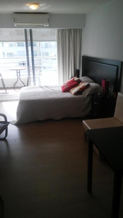 蒙得维的亚Edificio Go Pocitos的一间卧室设有一张床和一个大窗户