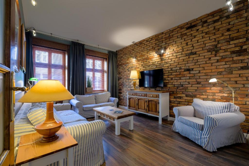波兹南Old House Apartments Poznań的带沙发和砖墙的客厅