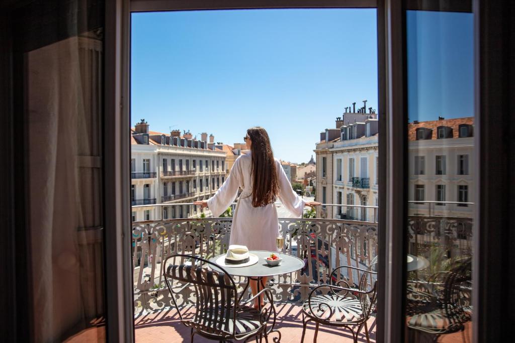 戛纳加文迪什酒店的站在一个眺望城市的阳台上的女人