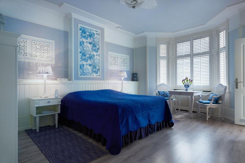 阿姆斯特丹翁德帕克住宿加早餐旅馆的一间卧室配有蓝色的床和一张书桌
