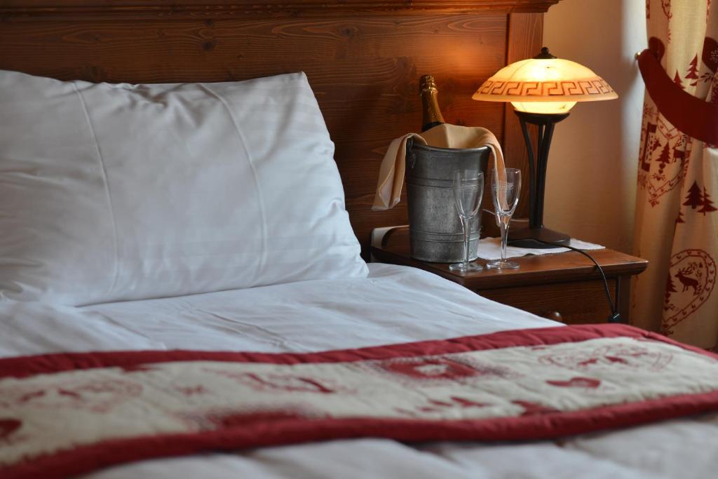 格吕耶尔格吕耶尔旅舍的一间卧室配有一张床、一盏灯和一瓶香槟