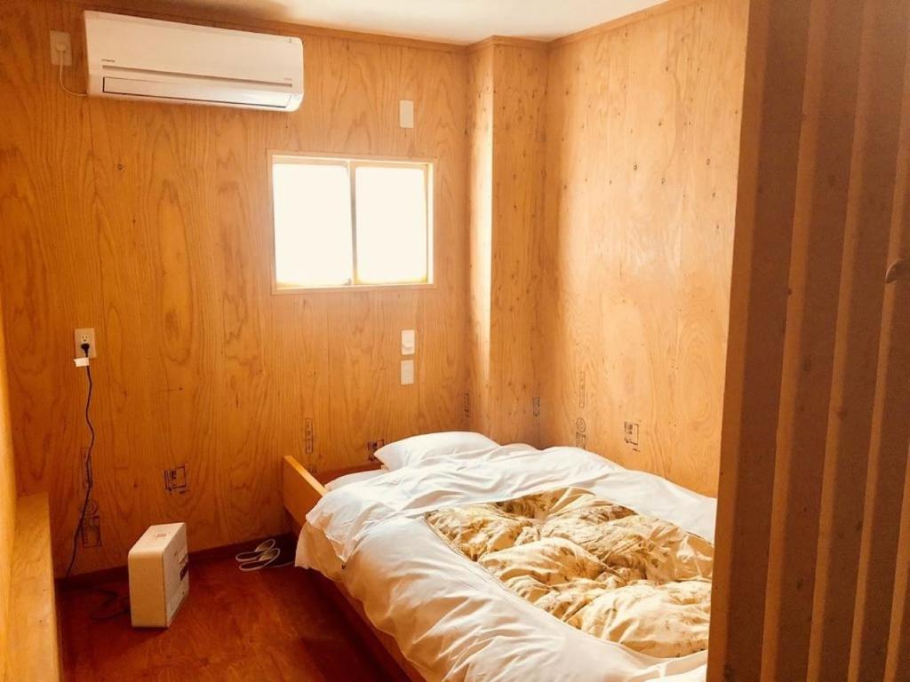 小樽Guesthouse Otaru Wanokaze single room / Vacation STAY 32196的一间带床的卧室,位于带窗户的房间内