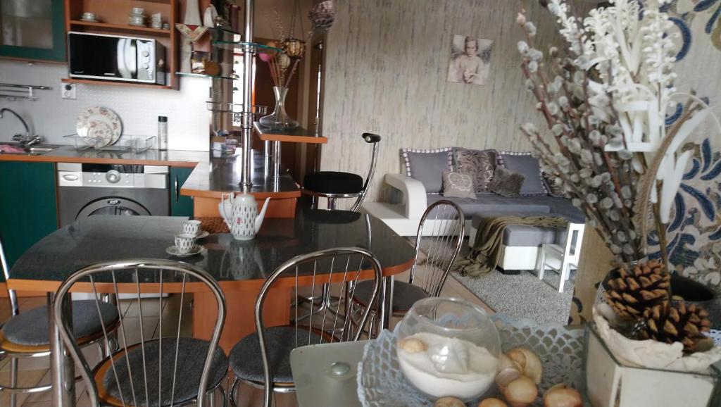 科马尔诺Apartmán Romance的厨房以及带桌椅的起居室。