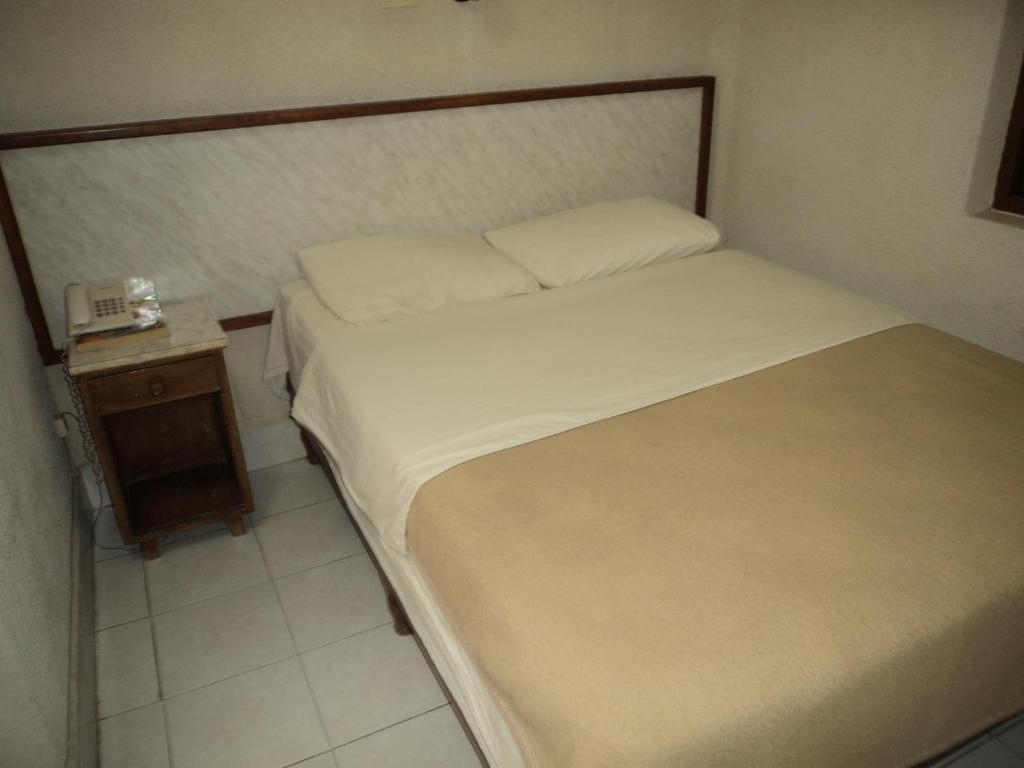 奥夫雷贡城库拉伊卡酒店的一间小卧室,配有床和床头柜