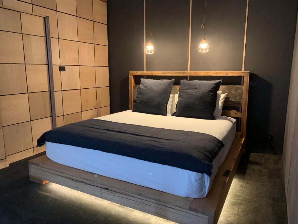 霍尔斯加普洛克斯公寓的一间卧室配有一张带两个枕头的木床