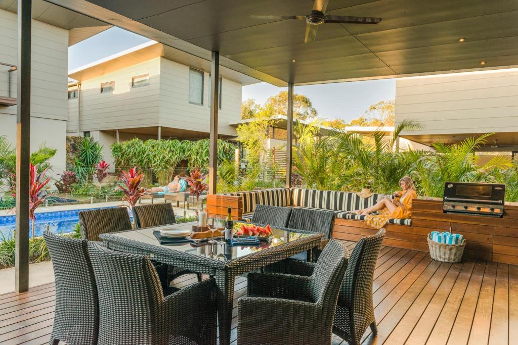 拜伦湾拜伦豪华海滨别墅酒店的一个带桌椅的庭院和一个游泳池