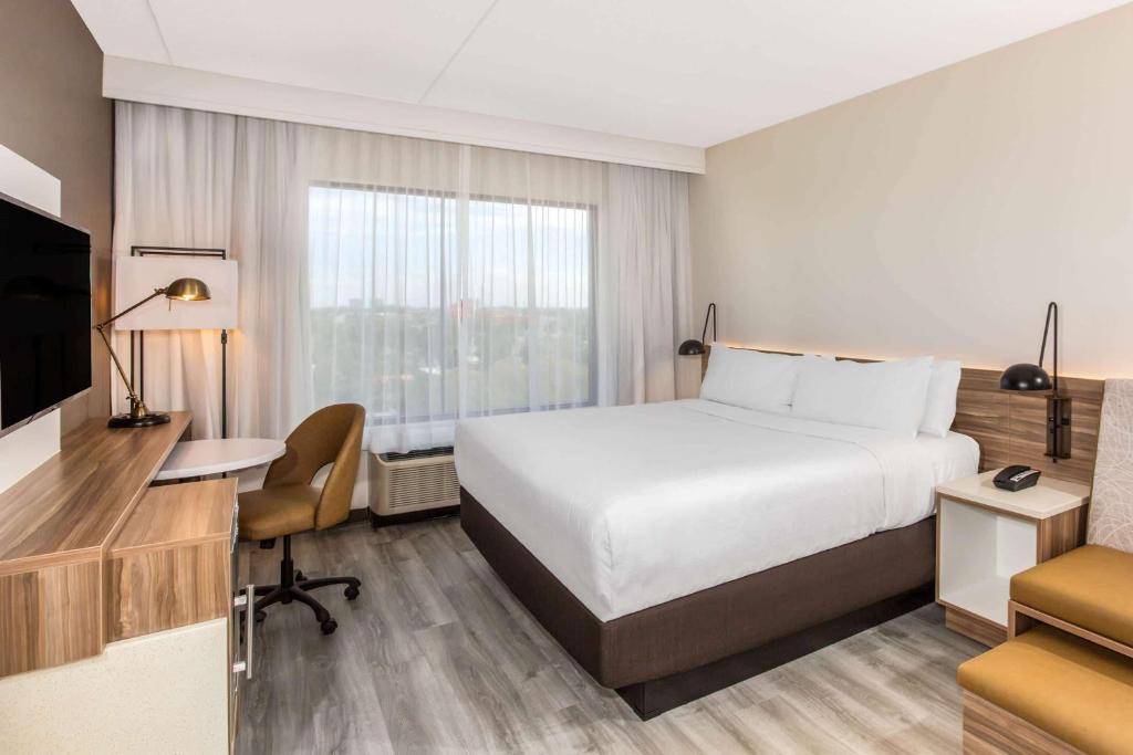 达尼亚滩Wyndham Garden Ft Lauderdale Airport & Cruise Port的酒店客房配有一张床、一张书桌和一台电视。