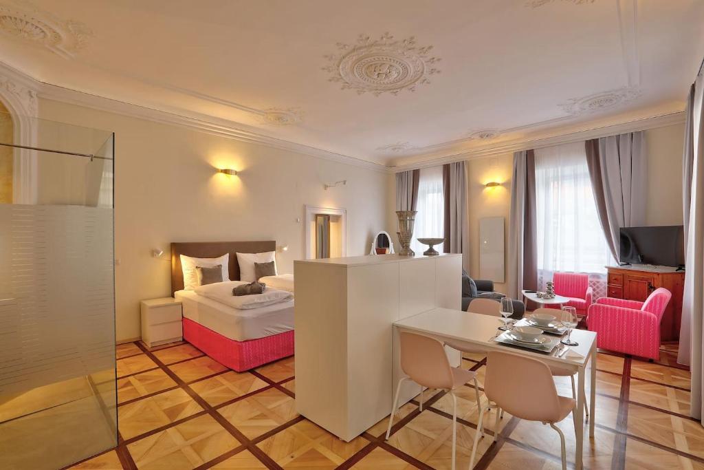 克拉根福Stylische Cityapartments Benedikt的酒店客房带一张床、一张桌子和椅子
