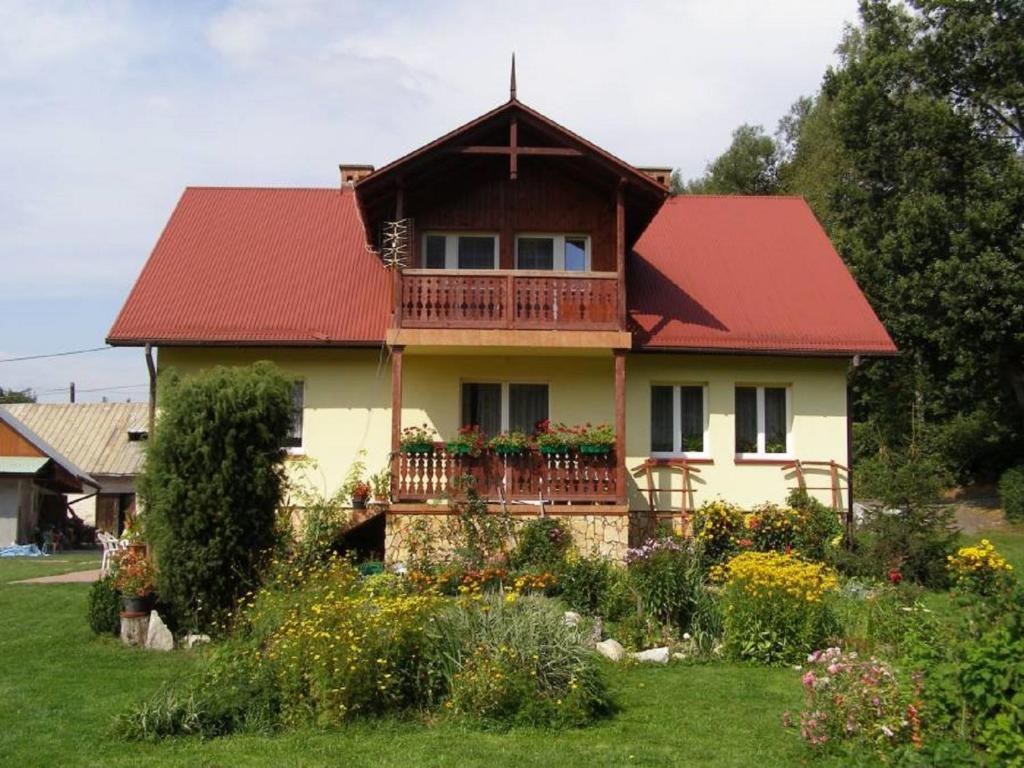 SułoszowaGospodarstwo Agroturystyczne Dolina Zachwytu的一座红色屋顶的房子和一个阳台