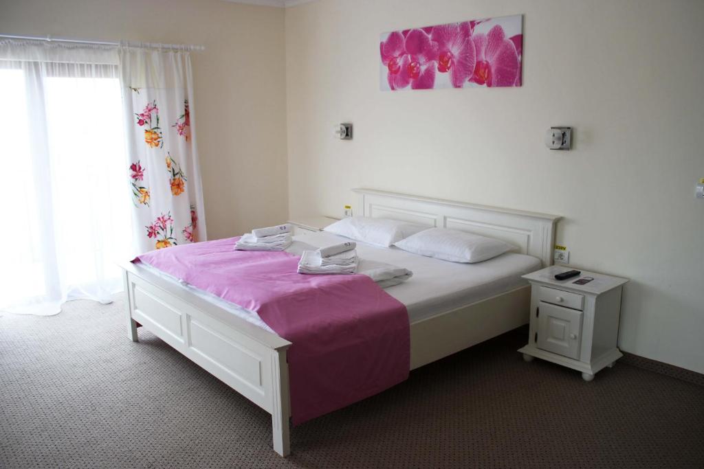 蒂米什瓦拉Pensiunea Casa Iorgovanul Urseni的卧室配有白色床和粉色毯子