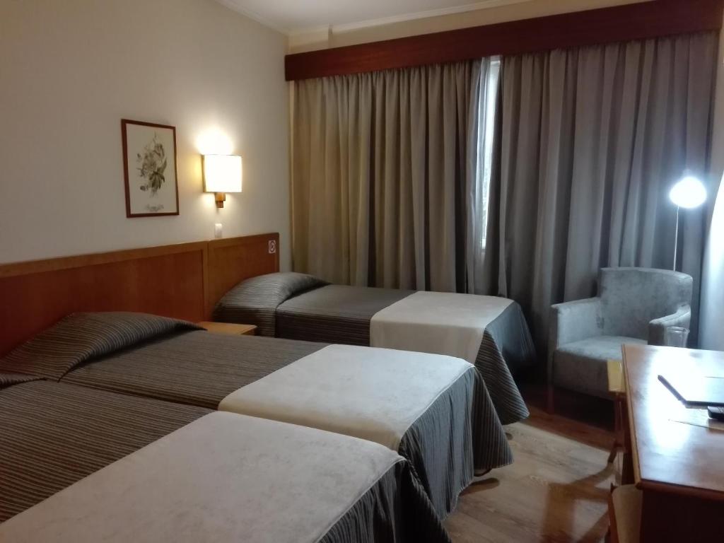 丰沙尔中心酒店的酒店客房,配有两张床和椅子