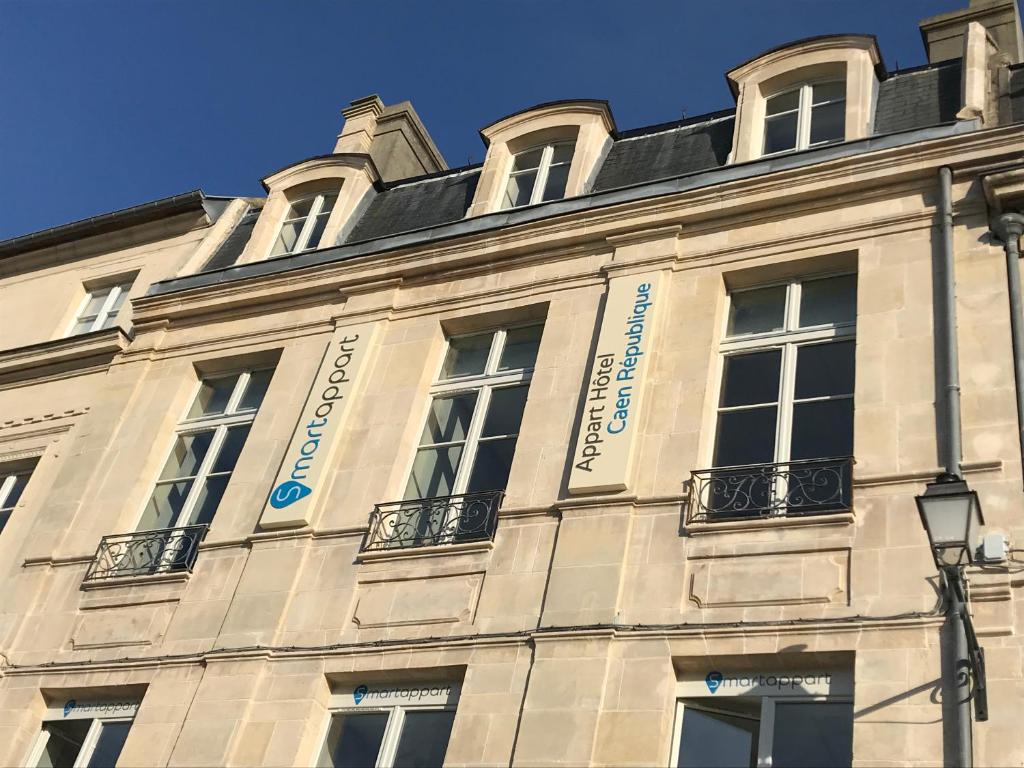 凯恩Smart Appart Caen République的白色的建筑,窗户在建筑的一侧