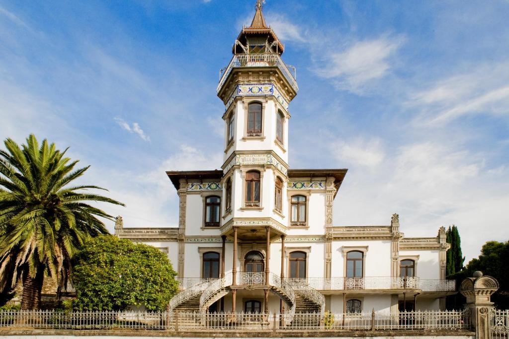 卡米尼亚Palacete Villa Idalina的一座白色的大建筑,设有钟楼