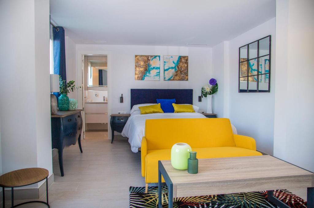 马贝拉Myra Apart-Hotel的一间卧室配有一张床和一张黄色的沙发