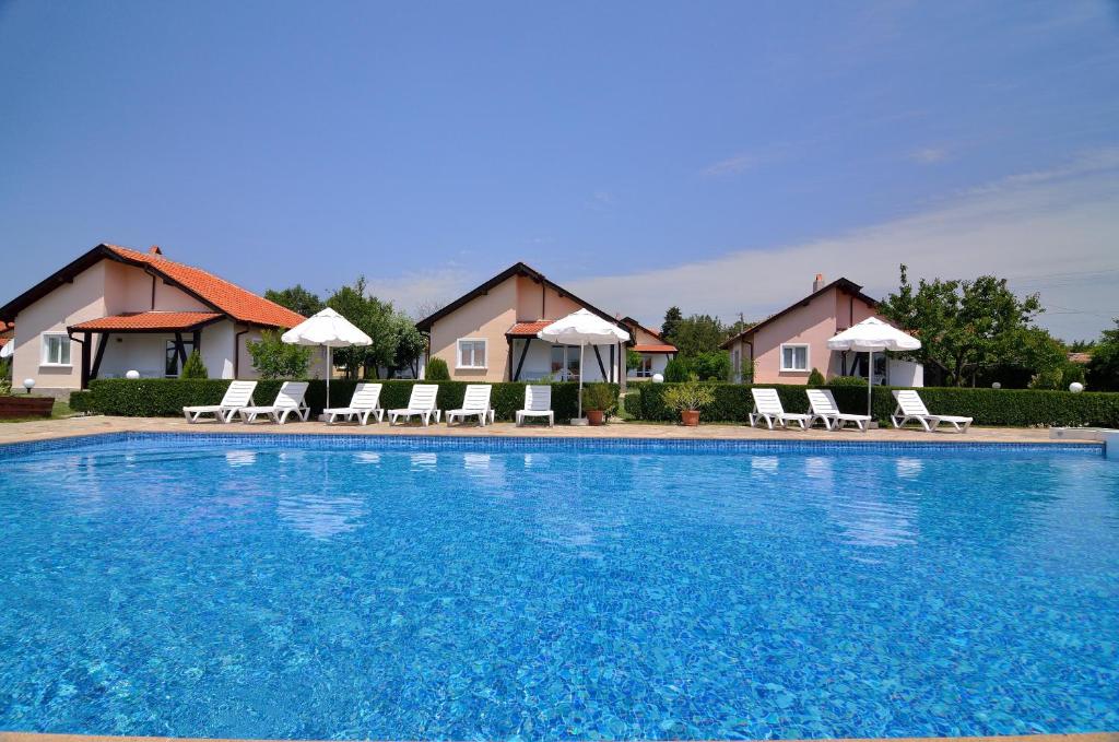 BryastovetsSunny Hills Villas的一个带椅子和遮阳伞的大型蓝色游泳池