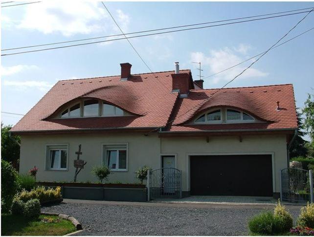 萨尔瓦尔Luca Vendégház的一座红色屋顶的房子和一个车库