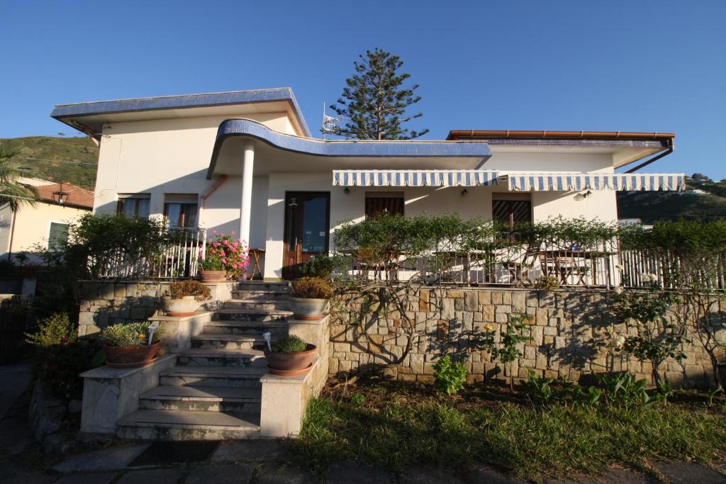 切法卢罗莎别墅住宿加早餐旅馆的楼梯上种有盆栽植物的白色房子