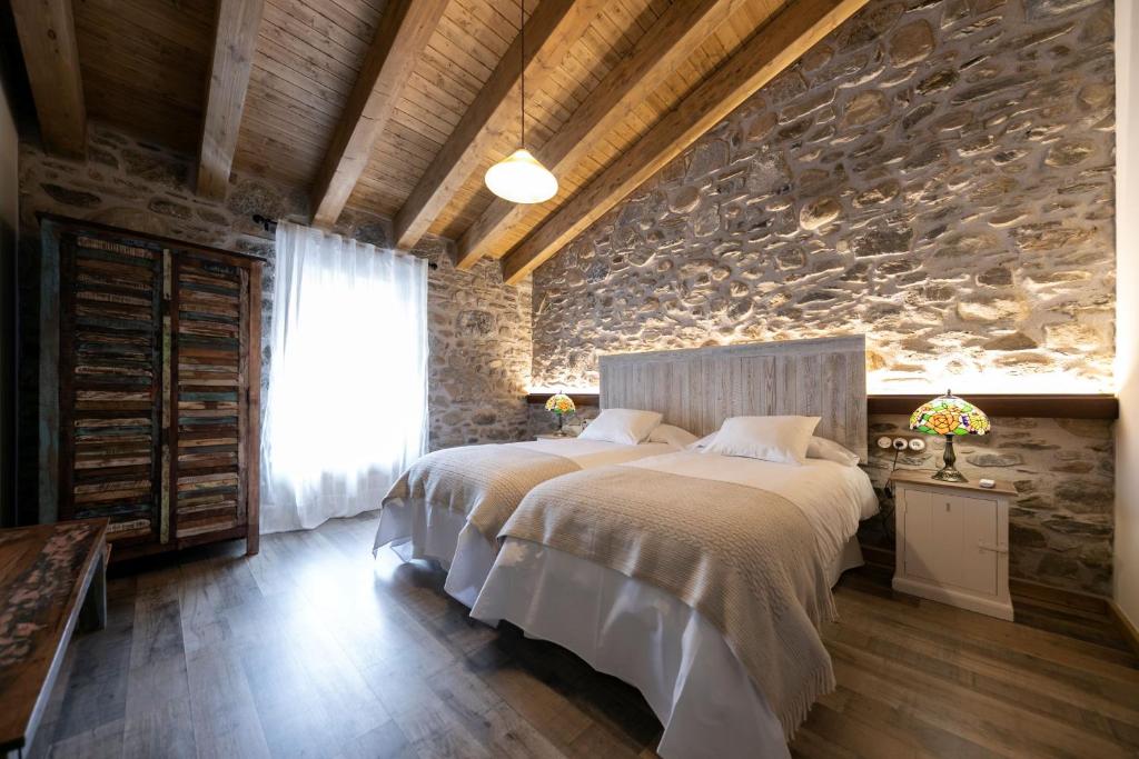 特尔河畔比拉利翁加Sports House Nord Sud (Only Adults)的一间卧室设有一张床和石墙
