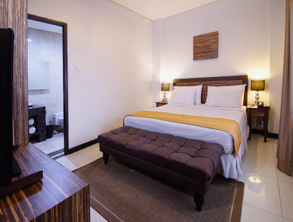 茂物茂物皇家酒店的一间卧室配有一张大床和一张沙发