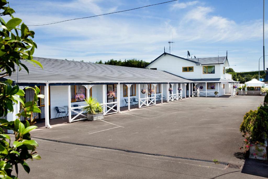 陶朗加Accommodation at Te Puna Motel的一座大型白色建筑,设有大型停车场