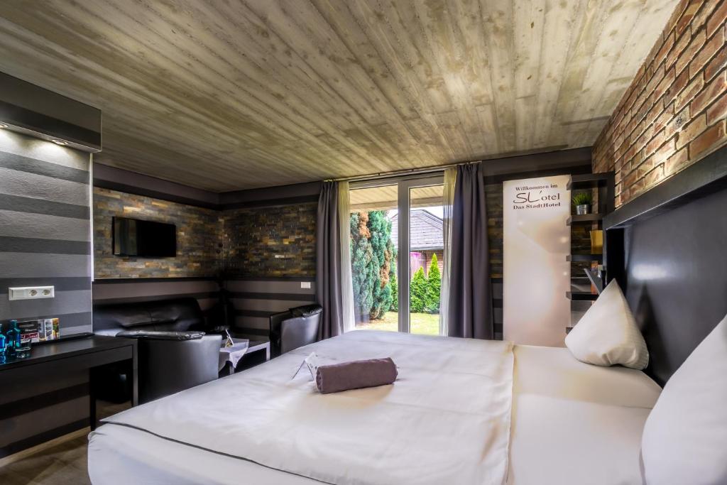 贝恩堡SL斯达斯酒店的卧室设有一张白色大床和一扇窗户。
