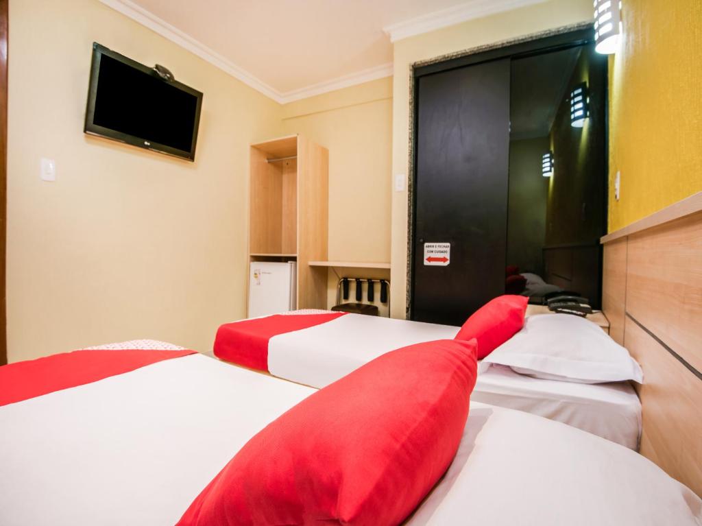 里约热内卢Hotel Villa Rica的酒店客房 - 带两张带红色枕头的床