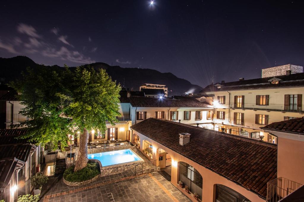 科莫阿尔伯格勒杜科缇酒店的享有大楼的景色,在晚上设有游泳池