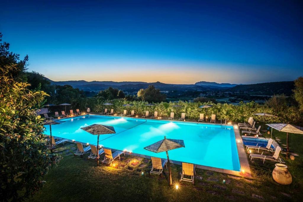 奥列纳苏过勒刚酒店的一张晚上游泳池的图片,上面有遮阳伞