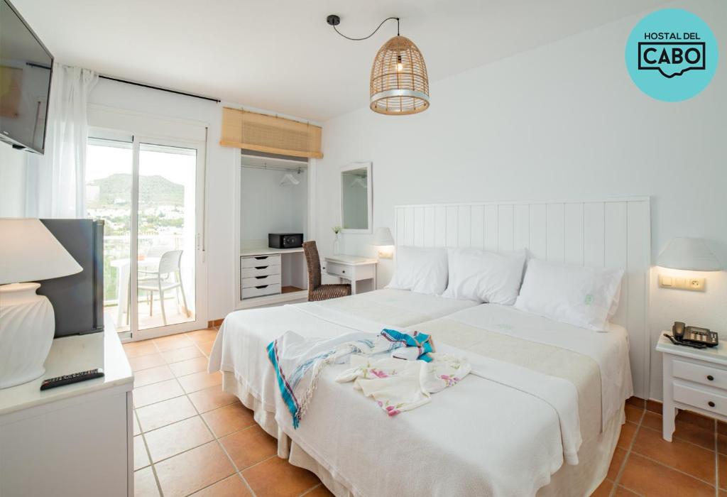 圣何塞Hostal del Cabo的卧室配有一张大白色床和电视。