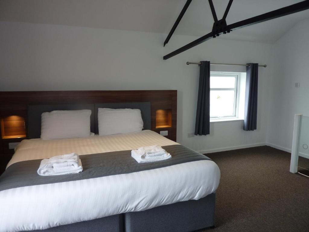切斯特Oakwood Farm Mews Chester的一间卧室配有一张大床和两条毛巾