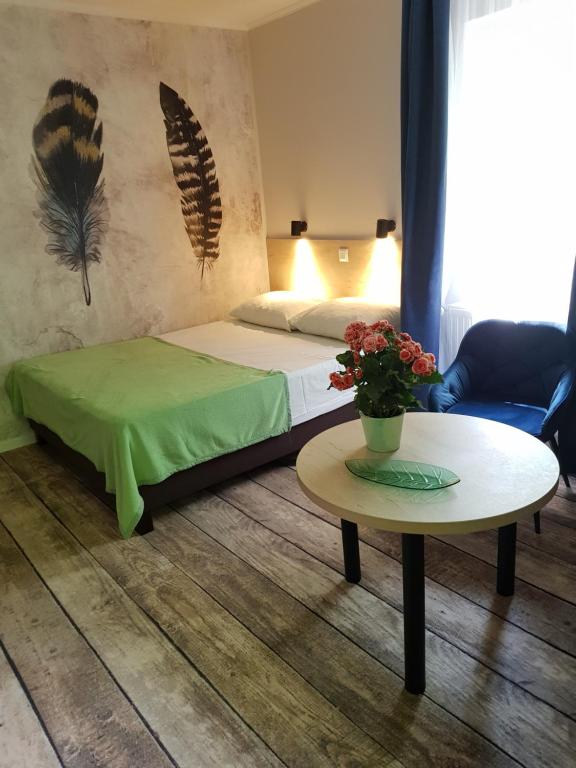 利拉菲赖德Erdővarázs Panzió的一间卧室配有一张床和一张鲜花桌子