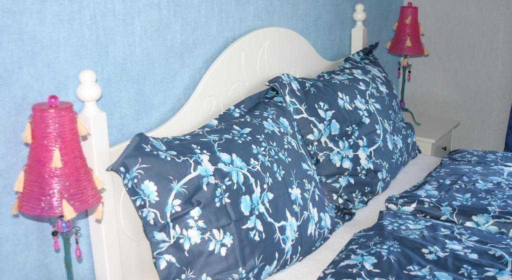 滨湖默尔比施Appartementhaus Das Mittelpunkt的一间卧室配有一张带蓝色和白色枕头的床