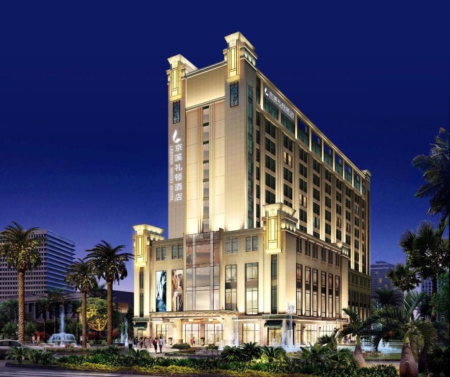 广州京溪礼顿酒店的一座大型酒店建筑,前面有棕榈树
